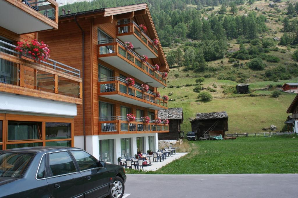 ein Gebäude mit einem davor geparkt in der Unterkunft Welcome Hotel Täsch by Täscherhof in Täsch