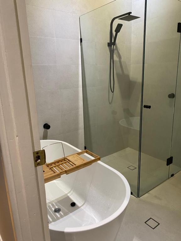 ein Bad mit einer Dusche und einem weißen Waschbecken in der Unterkunft Lg Qs Rm Private Luxury Bathrm Strictly NON SMOKERS and Genuine Travellers ONLY over 25 in Warnbro