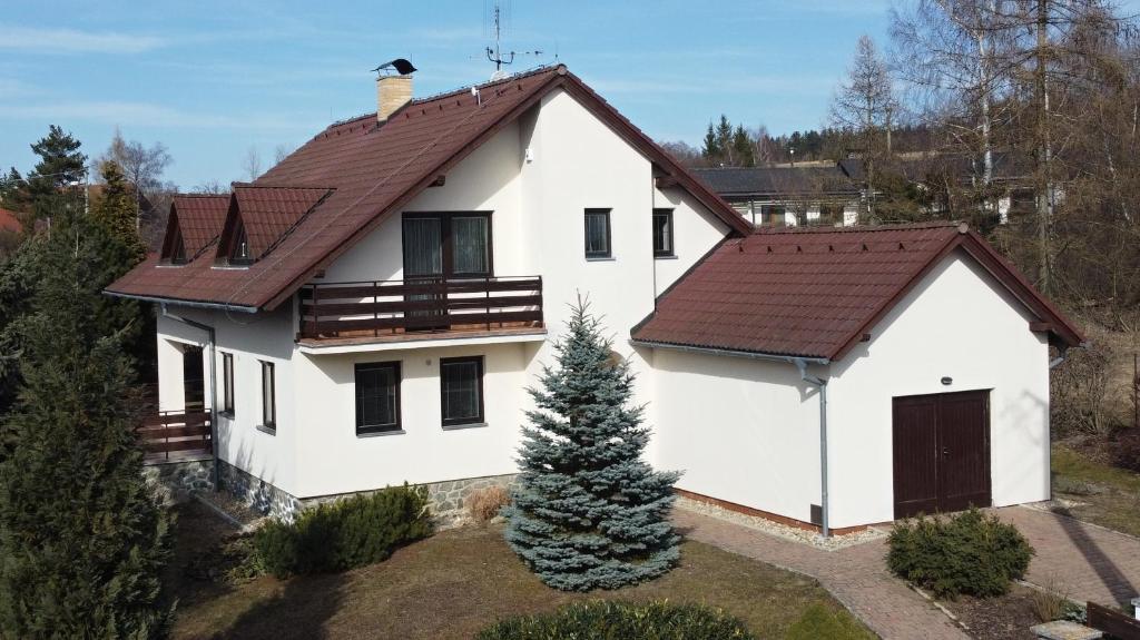 une maison blanche avec un toit marron dans l'établissement Chalupa u golfu Kořenec, à Kořenec