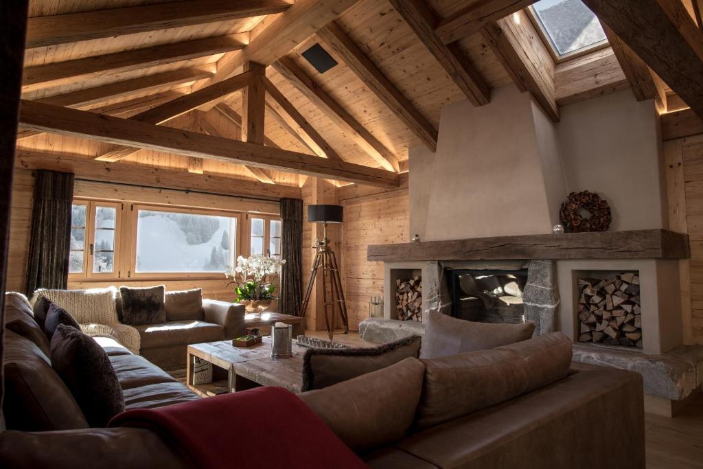 a living room with a couch and a fireplace at Grand Chalet de Rougemont in Rougemont