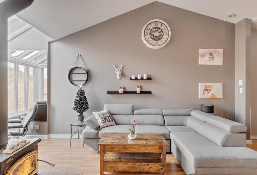 ein Wohnzimmer mit Sofa und Tisch in der Unterkunft Le Cozy-Condo à louer à Stoneham (CITQ 239956) in Stoneham