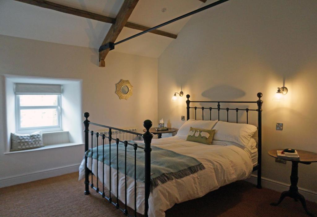 um quarto com uma cama e uma janela em Brook Cottage Askrigg em Askrigg