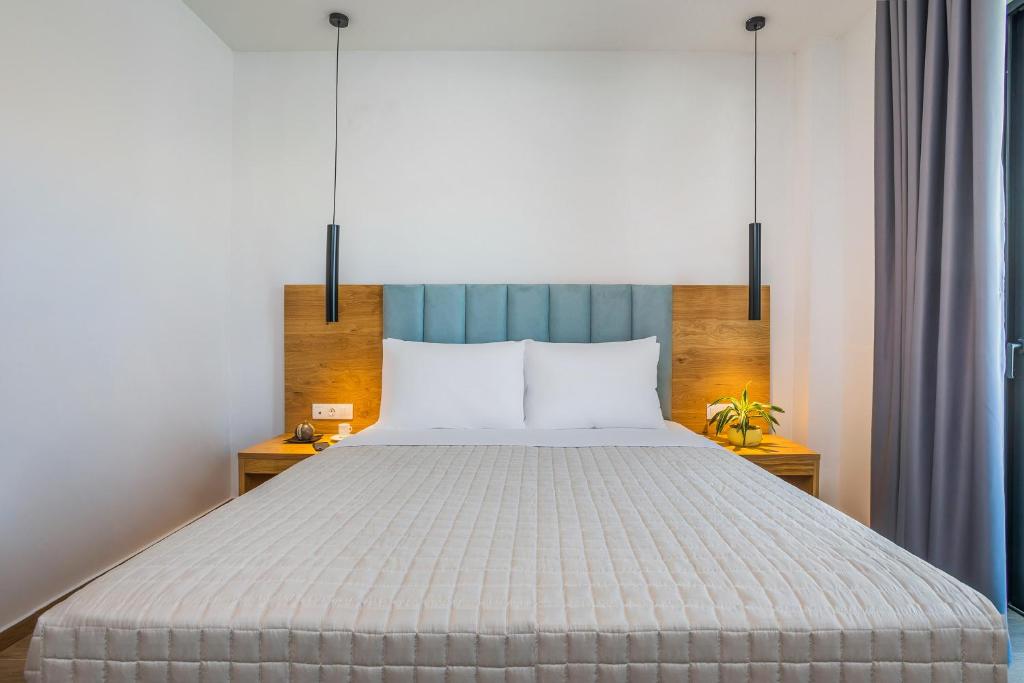 a bedroom with a large bed with a blue headboard at AlexMare Hotel Fourka in Skala Fourkas