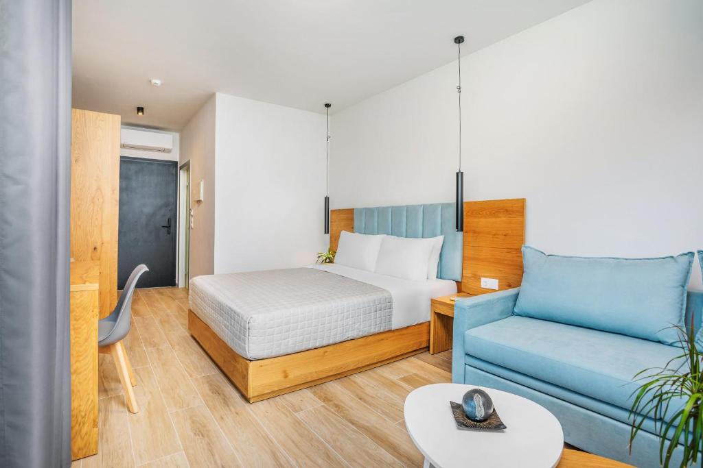 a hotel room with a bed and a couch at AlexMare Hotel Fourka in Skala Fourkas