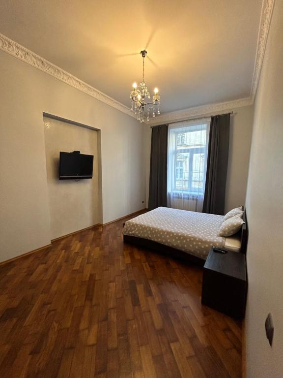 a bedroom with a bed and a large window at APARTMENT ON CENTRE LVIV in Lviv