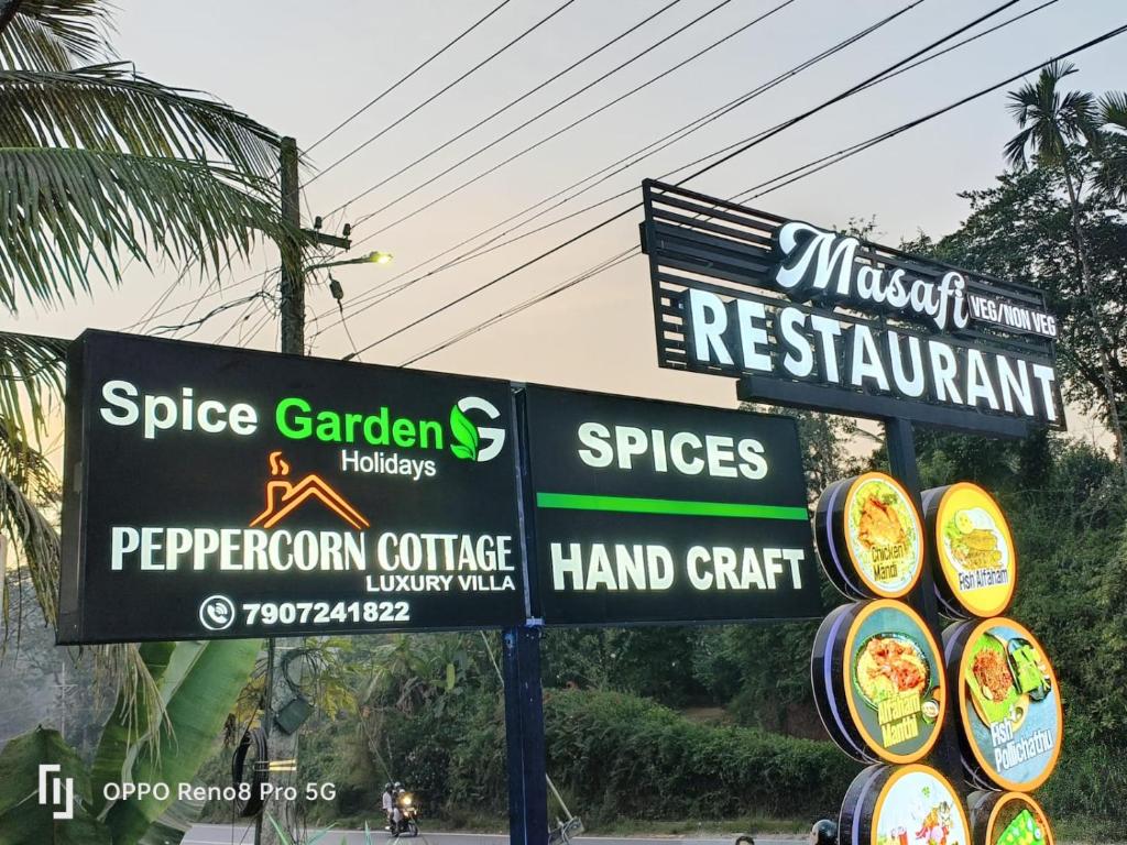 a bunch of signs on the side of a street at Peppercorn Cottage, Vythiri. in Vythiri