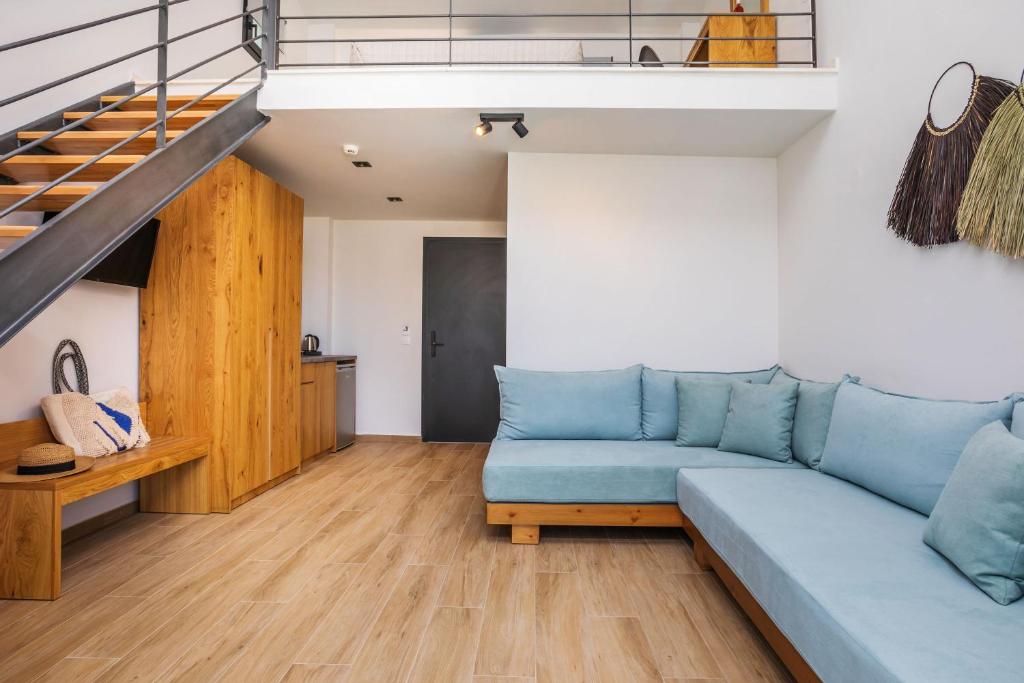a living room with a blue couch and a staircase at AlexMare Hotel Fourka in Skala Fourkas