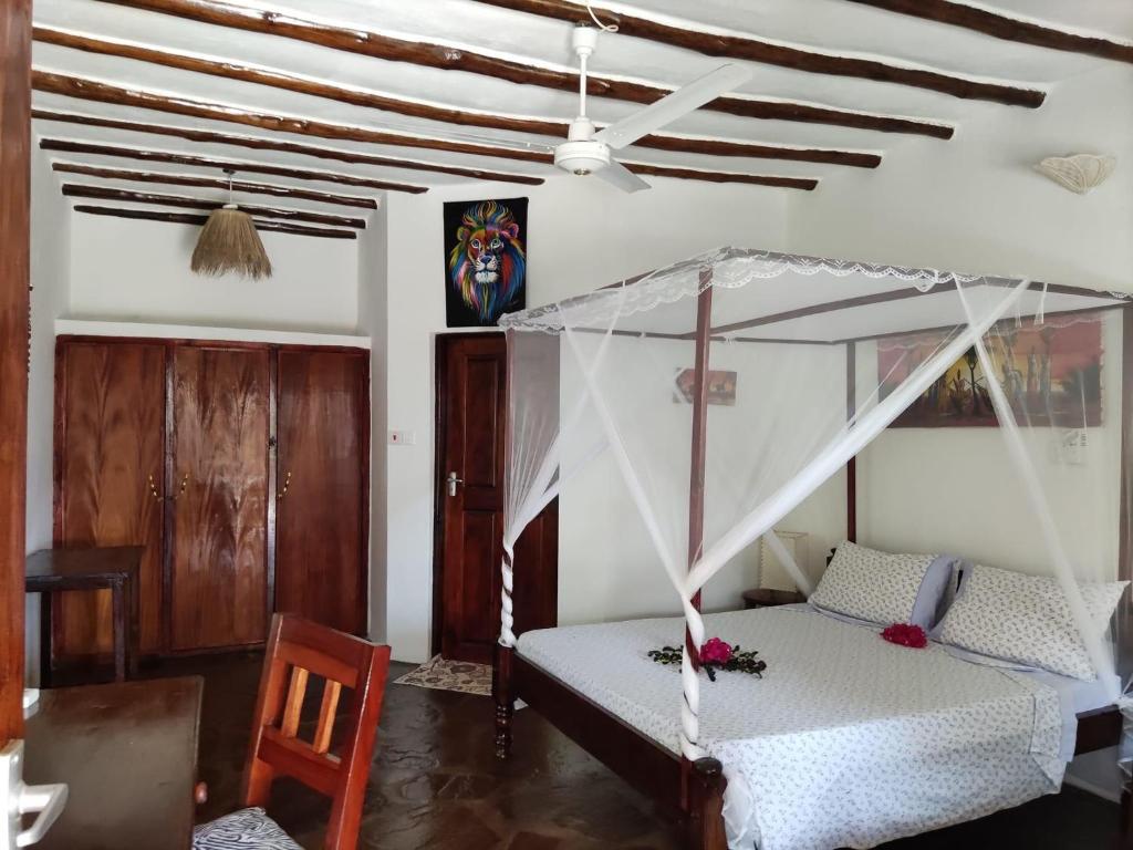 a bedroom with a bed with a canopy at BeB Sardegna2 Anjumasa village in Watamu