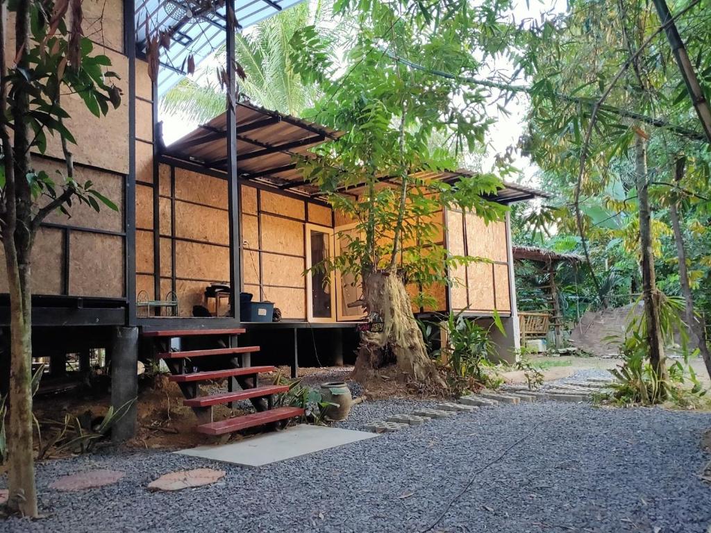 ein kleines Haus mit seitlicher Veranda in der Unterkunft แม่ไพโฮมสเตย์ ล่องแพกอนโดล่า 