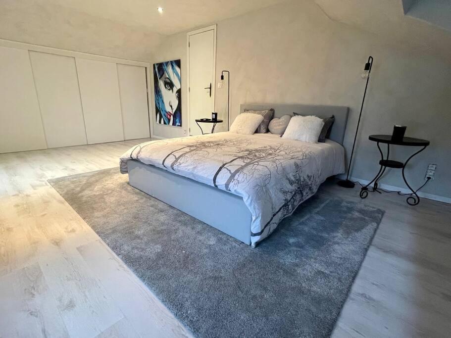 a bedroom with a large bed and a table at Charmante maison de vacances in Vaux-sur-Sûre