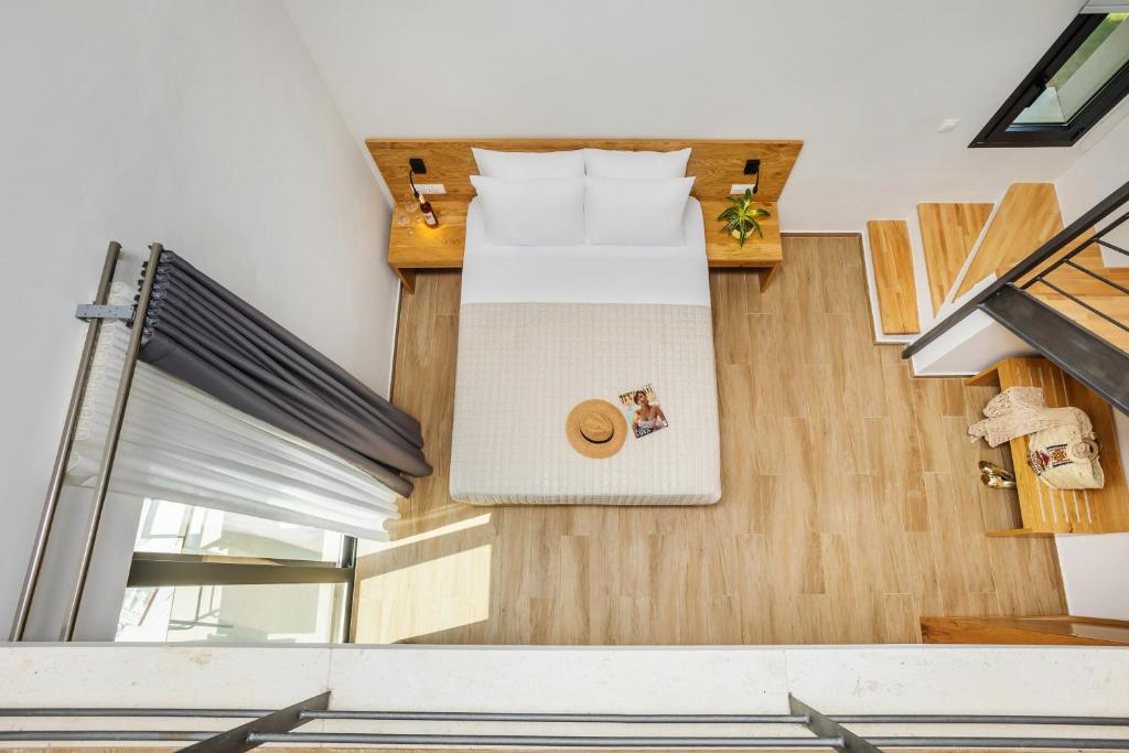 a bedroom with a bed and wooden floors at AlexMare Hotel Fourka in Skala Fourkas