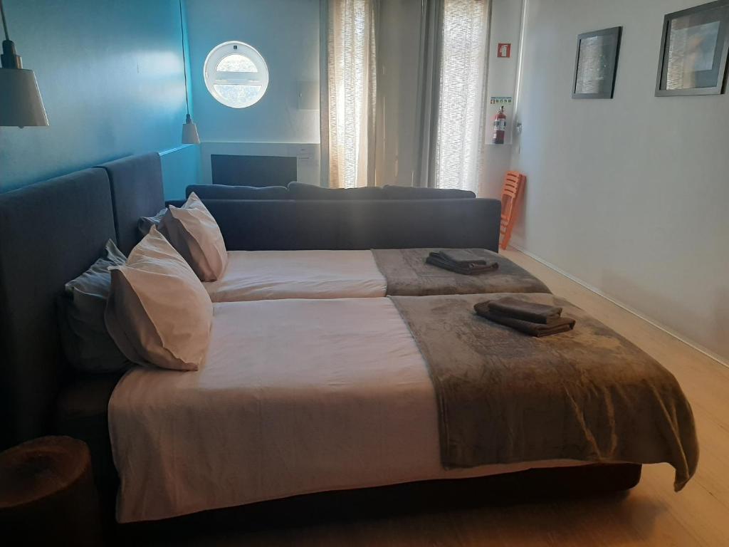 a bedroom with a large bed and a couch at Quartos do Seixe - Azul in Odeceixe