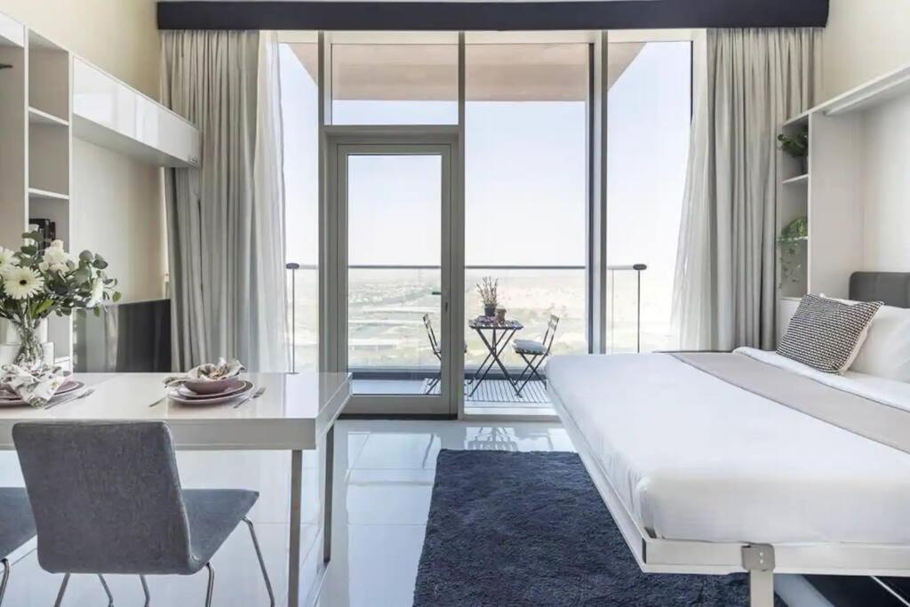 a bedroom with a large white bed and a dining table at Miraclz Skyline Tower in Dubai