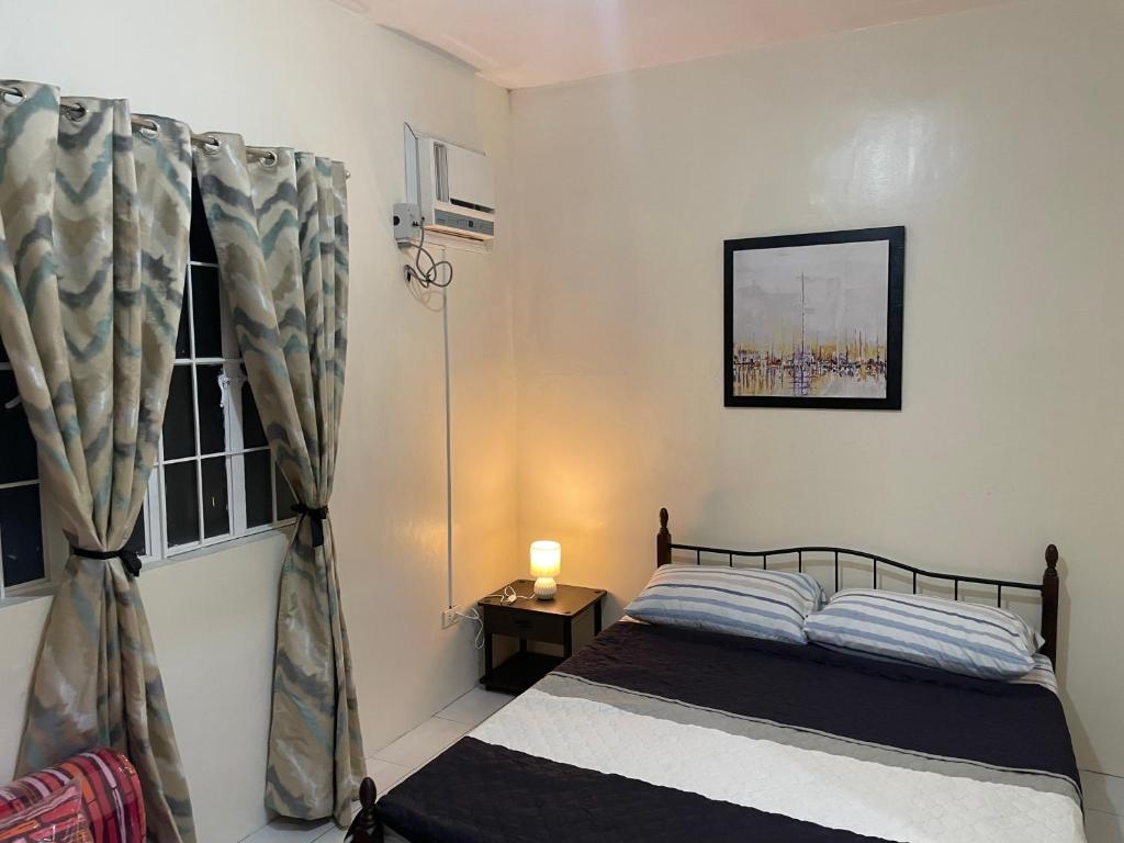 a bedroom with a bed and a window at Townhouse Apartment near SM City Lucena in Lucena