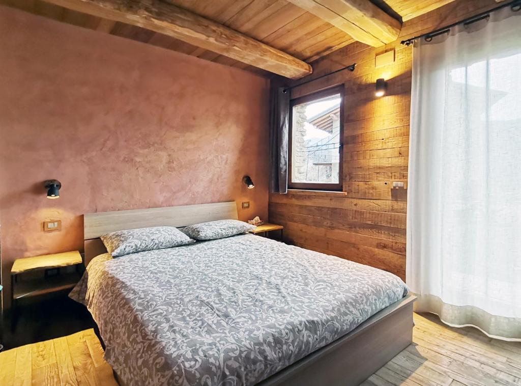 a bedroom with a bed and a window in it at Ca' Maira Casa di montagna in Val Maira con vista in Roccabruna