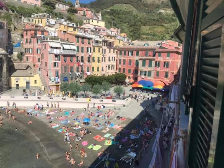 a crowd of people on a beach with umbrellas at Albergo Barbara in Vernazza