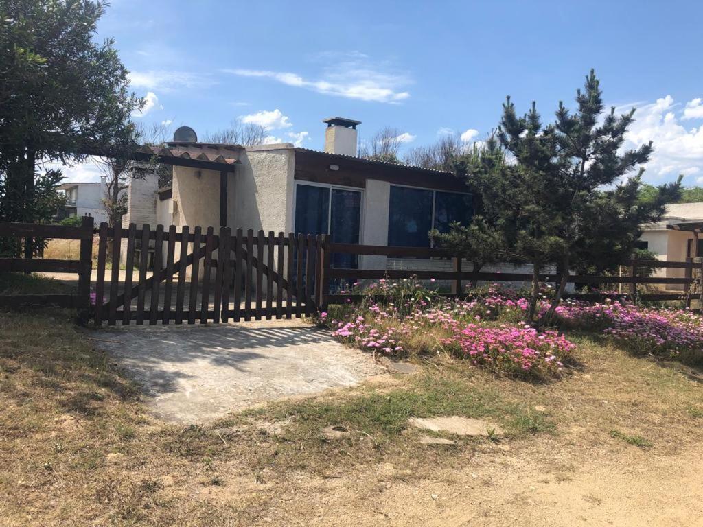 una casa con una valla de madera y flores en Los Pachis, en La Paloma
