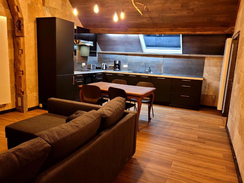 sala de estar con sofá, mesa y cocina en Chez Claude appartement cozy climatisé pour 4 personnes tout confort, en Ath