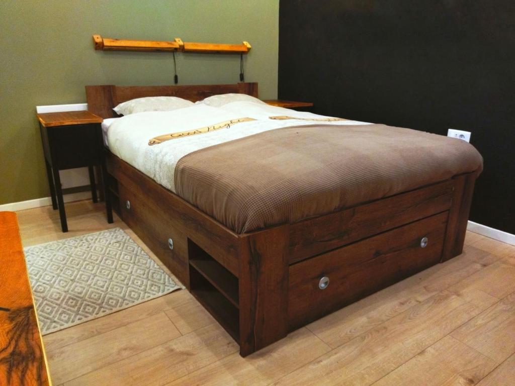 - un lit avec un cadre en bois dans une chambre dans l'établissement Apartment Candy, à Zagreb