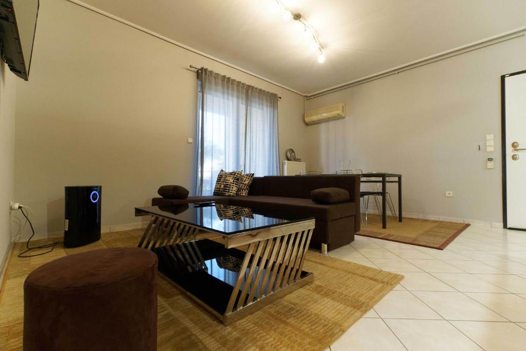 Cozy & Relaxing Apartments-Agia Paraskevi في أثينا: غرفة معيشة مع أريكة وطاولة