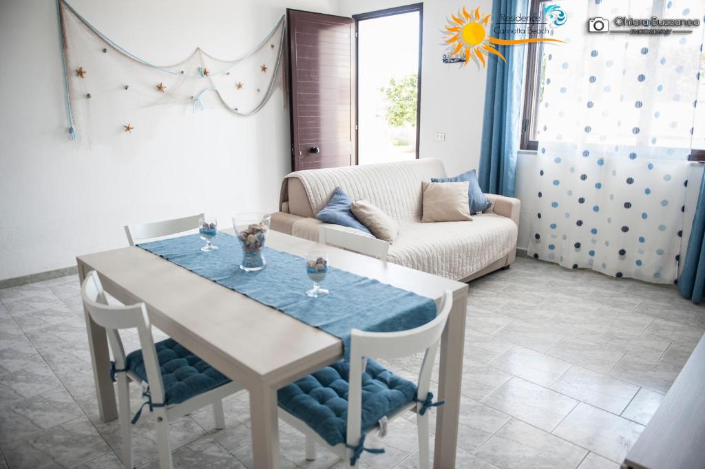 ein Wohnzimmer mit einem Tisch und einem Sofa in der Unterkunft Cannotta Beach - Salina in Terme Vigliatore