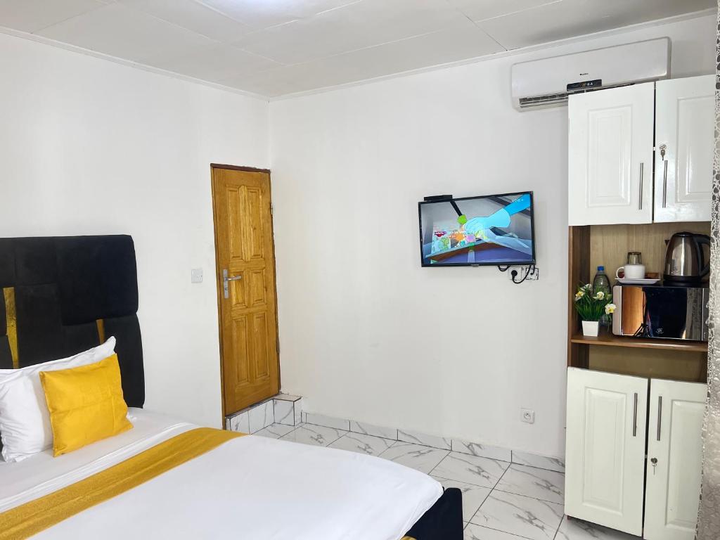 a bedroom with a bed and a tv on the wall at Chambre Moderne (Kotto) in Douala