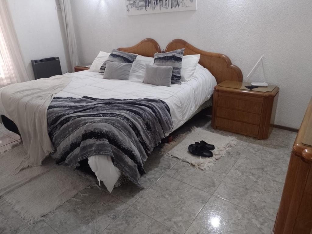 1 dormitorio con 1 cama grande y cabecero de madera en Casa Alvear en Marcos Juárez