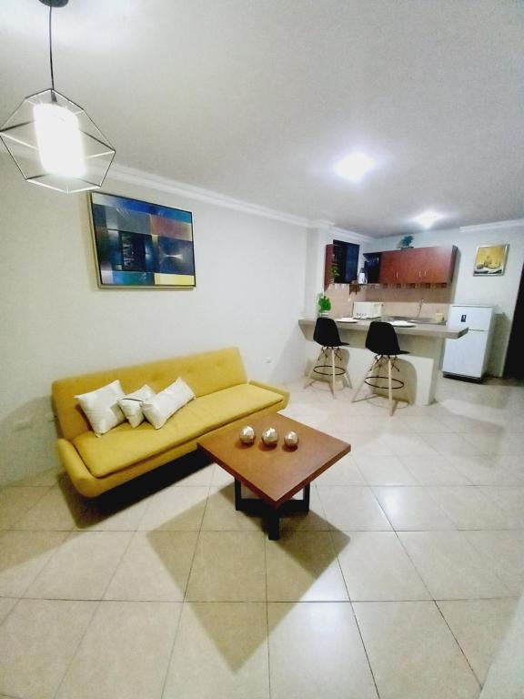 sala de estar con sofá amarillo y mesa en Apartamento moderno cerca del aeropuerto, en Guayaquil
