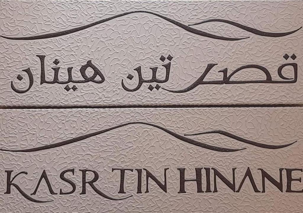 two signs with the names of two countries in arabic writing at Kasr Tin Hinane in Merzouga