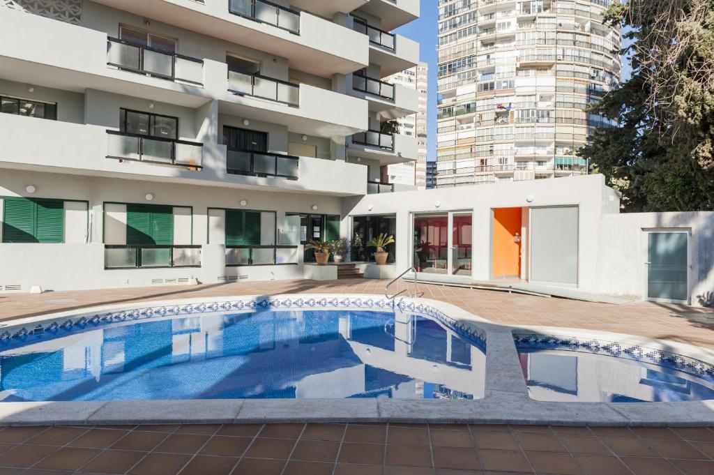 a large swimming pool in a large building at Apartamentos Michel Angelo Benidorm in Benidorm