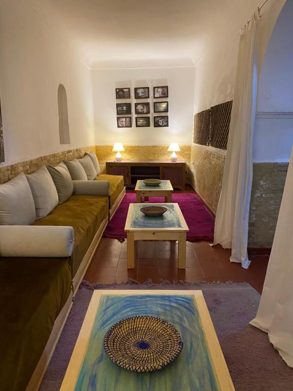 sala de estar con sofá y mesa en Riad Dar Lilas, en Marrakech