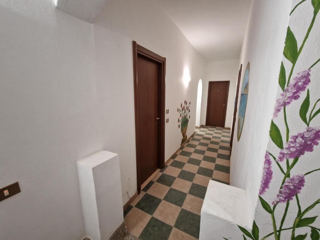 a hallway with a checkered floor and a door at Monolocali in centro paese in Lampedusa