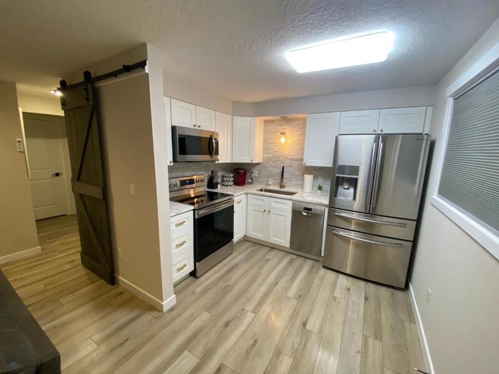 a kitchen with white cabinets and stainless steel appliances at Valley Escape in Quiet Area Neighborhood in Spokane Valley