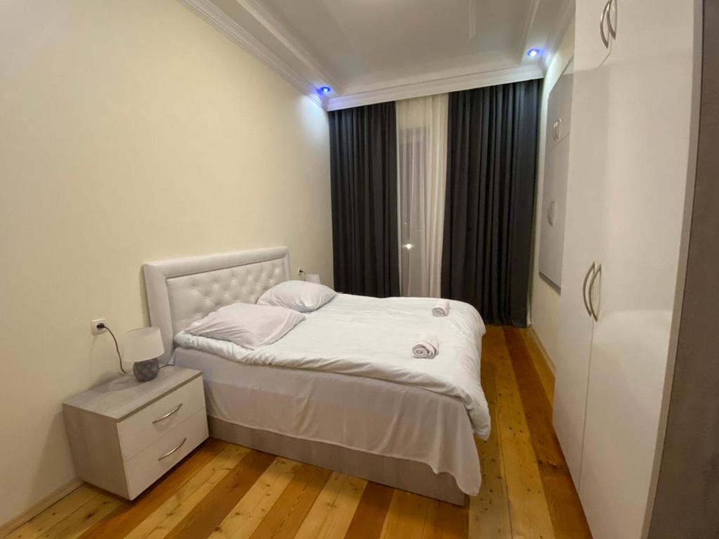 a small bedroom with a white bed and a window at Guesthouse LUKA in Kutaisi