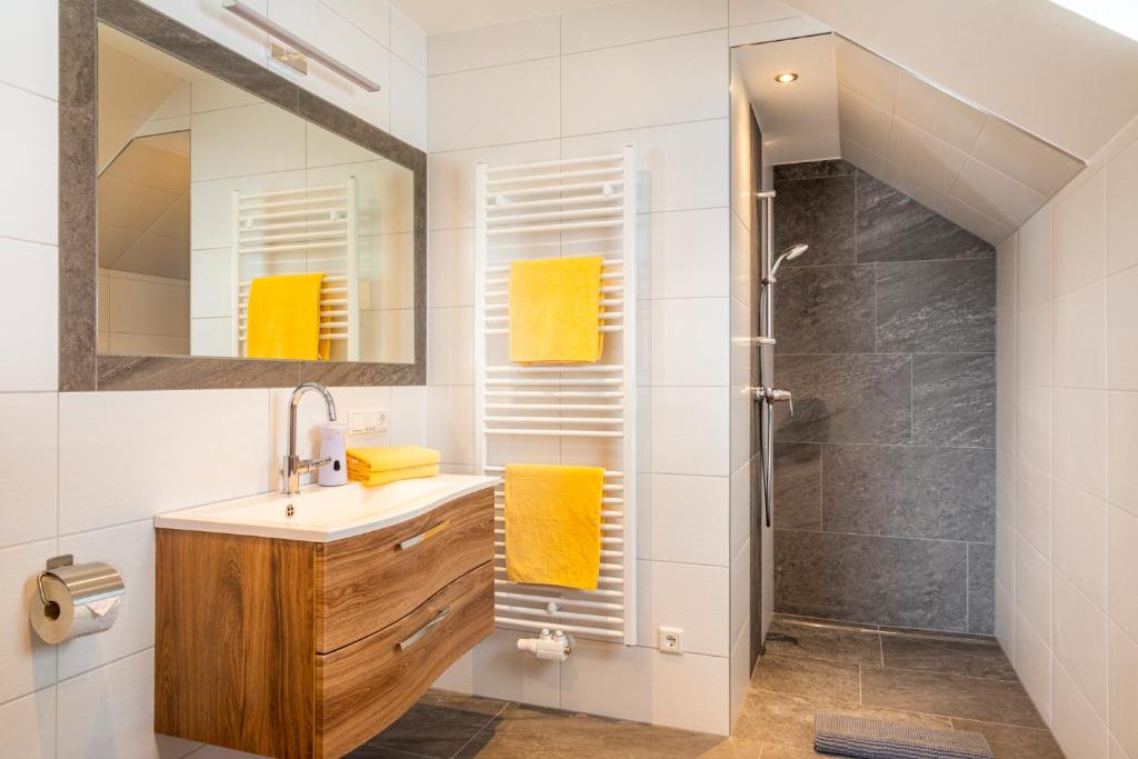 ein Badezimmer mit einem Waschbecken und einer Dusche mit gelben Handtüchern in der Unterkunft Moamoosgut in Göriach