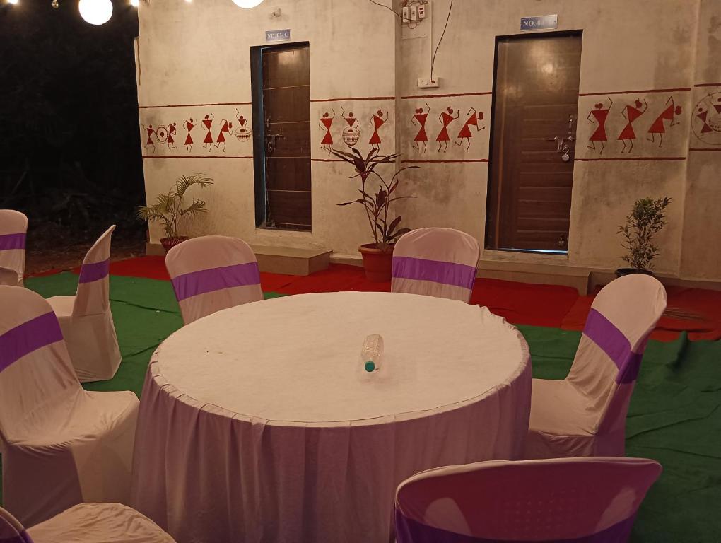 a room with a white table and chairs at Mhatre Cottage Alibag Mani in Alibaug