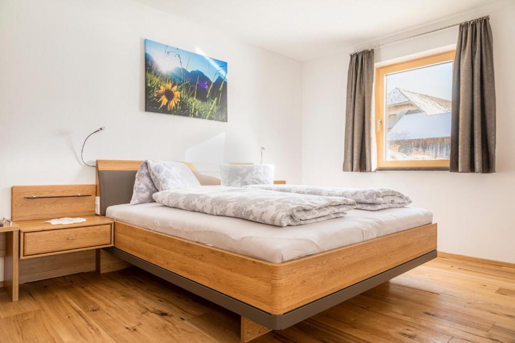 ein Schlafzimmer mit einem Bett und einem hölzernen Nachttisch in der Unterkunft Moamoosgut in Göriach
