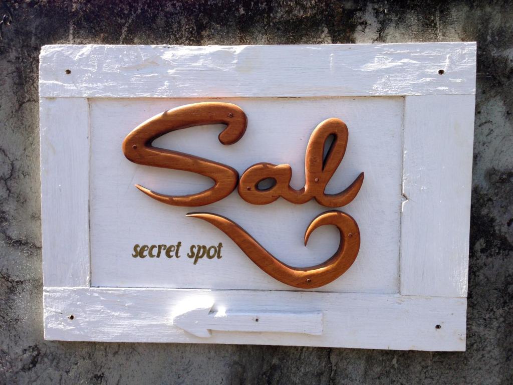 a white sign with a pretzel on it at Sal Secret Spot in Uluwatu