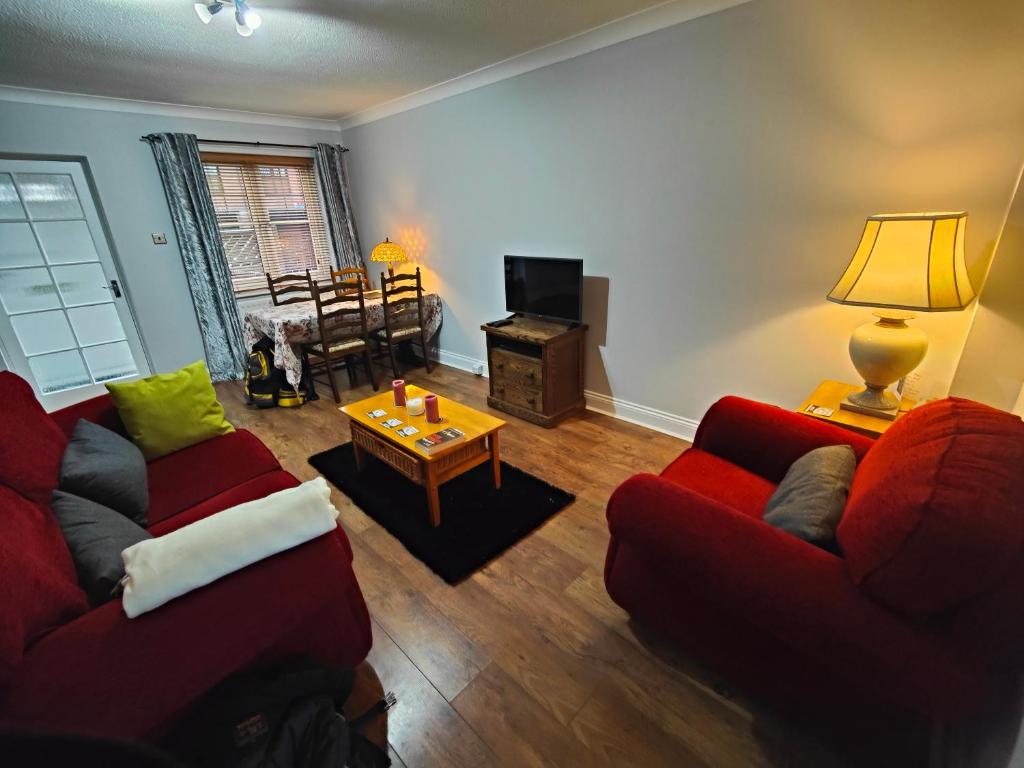 a living room with two red couches and a table at Great place in Newcastle in Newcastle upon Tyne