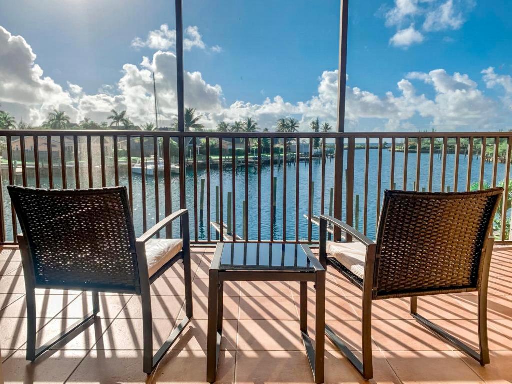 フリーポートにあるEntire Home - Relaxing Ocean View Condoのバルコニー(椅子2脚、テーブル1台、水辺付)