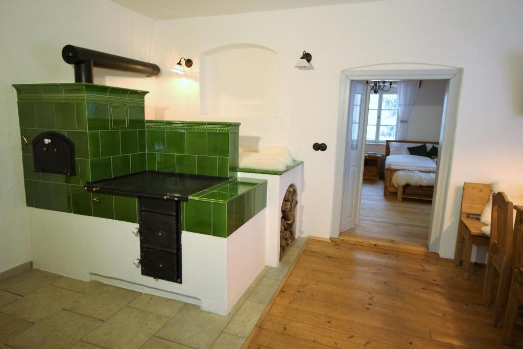 a kitchen with a stove with green tile on the wall at Chalupa Fara in Dolní Malá Úpa