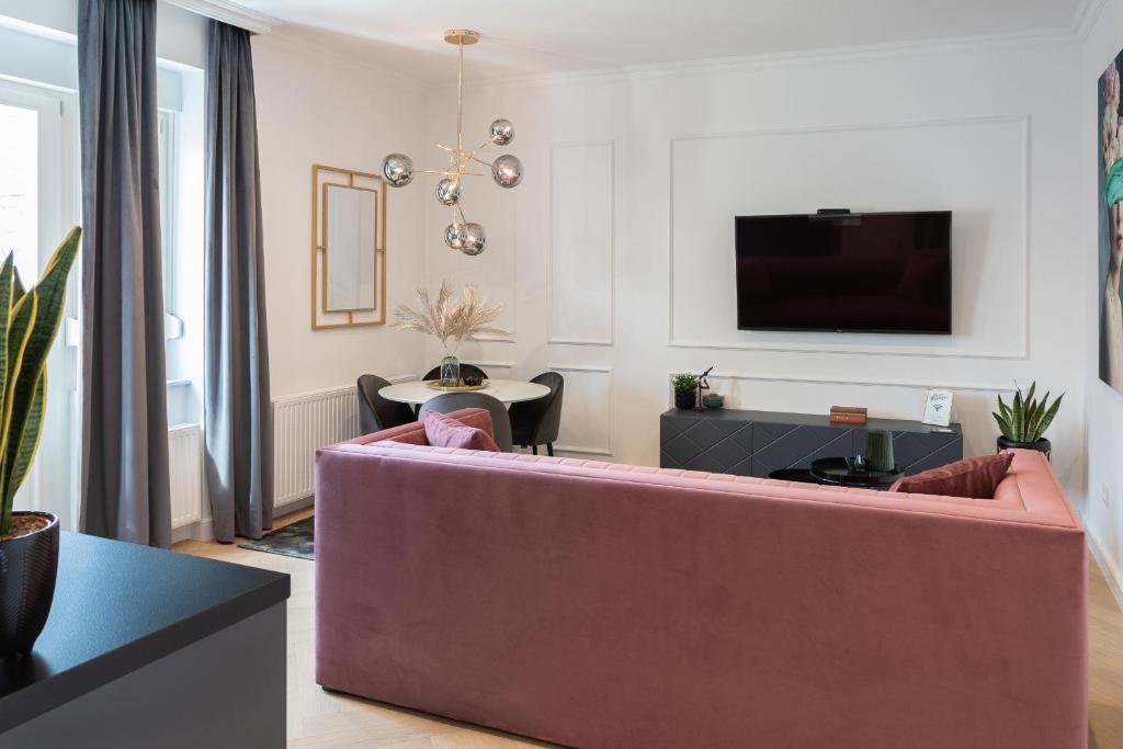 Una sala de estar con un sofá y un televisor. en Candy Ballerina No 1 Zagreb Center - top positon Lux, en Zagreb