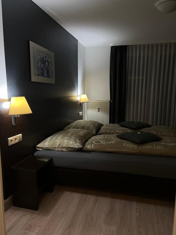 ein Schlafzimmer mit einem Bett mit einer schwarzen Wand in der Unterkunft T24 - Ihr Appartement mit Charakter in Sindelfingen