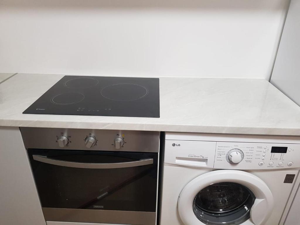 uma cozinha com um fogão e uma máquina de lavar roupa em V&V 