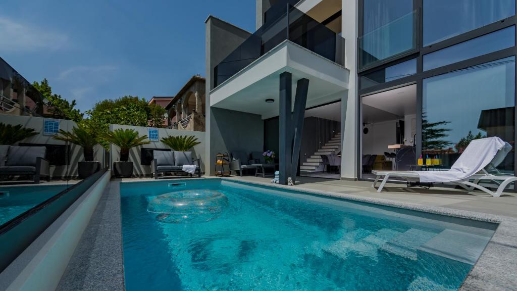 a swimming pool in front of a house at Villa Skrisia in Cesarica