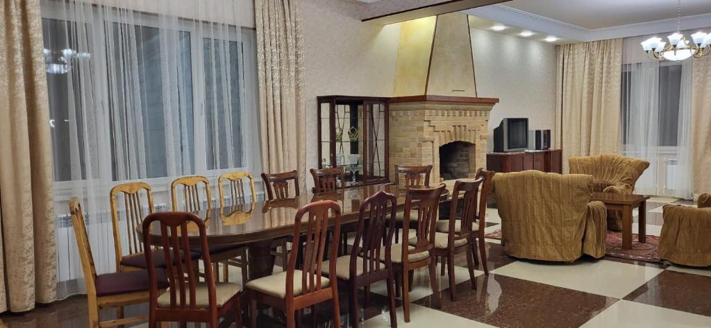 comedor con mesa, sillas y chimenea en Dream garden en Karbi