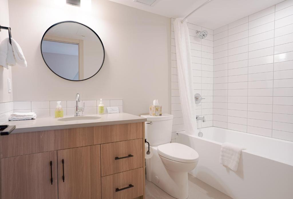 a bathroom with a sink toilet and a mirror at Basecamp Suites Banff in Banff