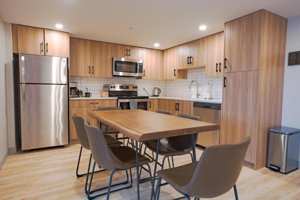 a kitchen with a table and chairs and a refrigerator at Basecamp Suites Banff in Banff