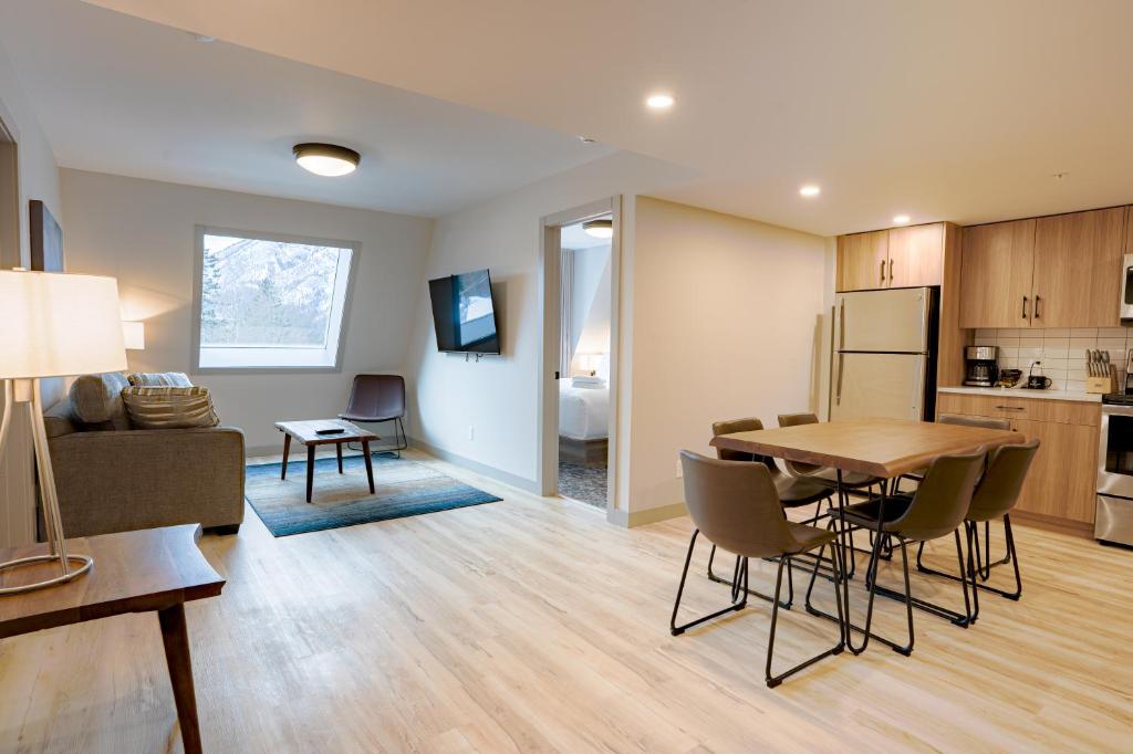 a kitchen and a living room with a table and chairs at Basecamp Suites Banff in Banff