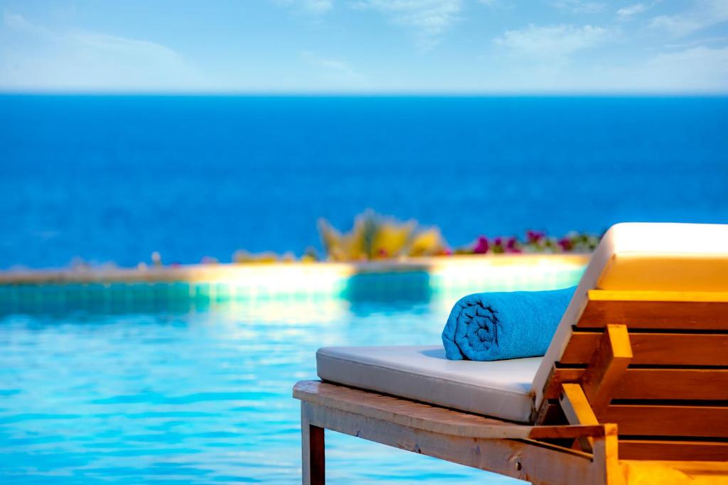 Zen Resort Sahl Hasheesh by TBH Hotels في الغردقة: سرير جالس على مرسى بجانب سفح ماء